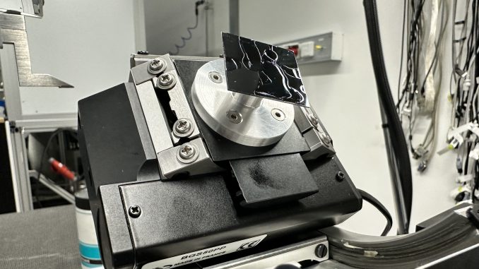 A scrap wafer mounted on our GI sample holder, held on with grease. The sample is tilted at the maximum angle to investigate stability.